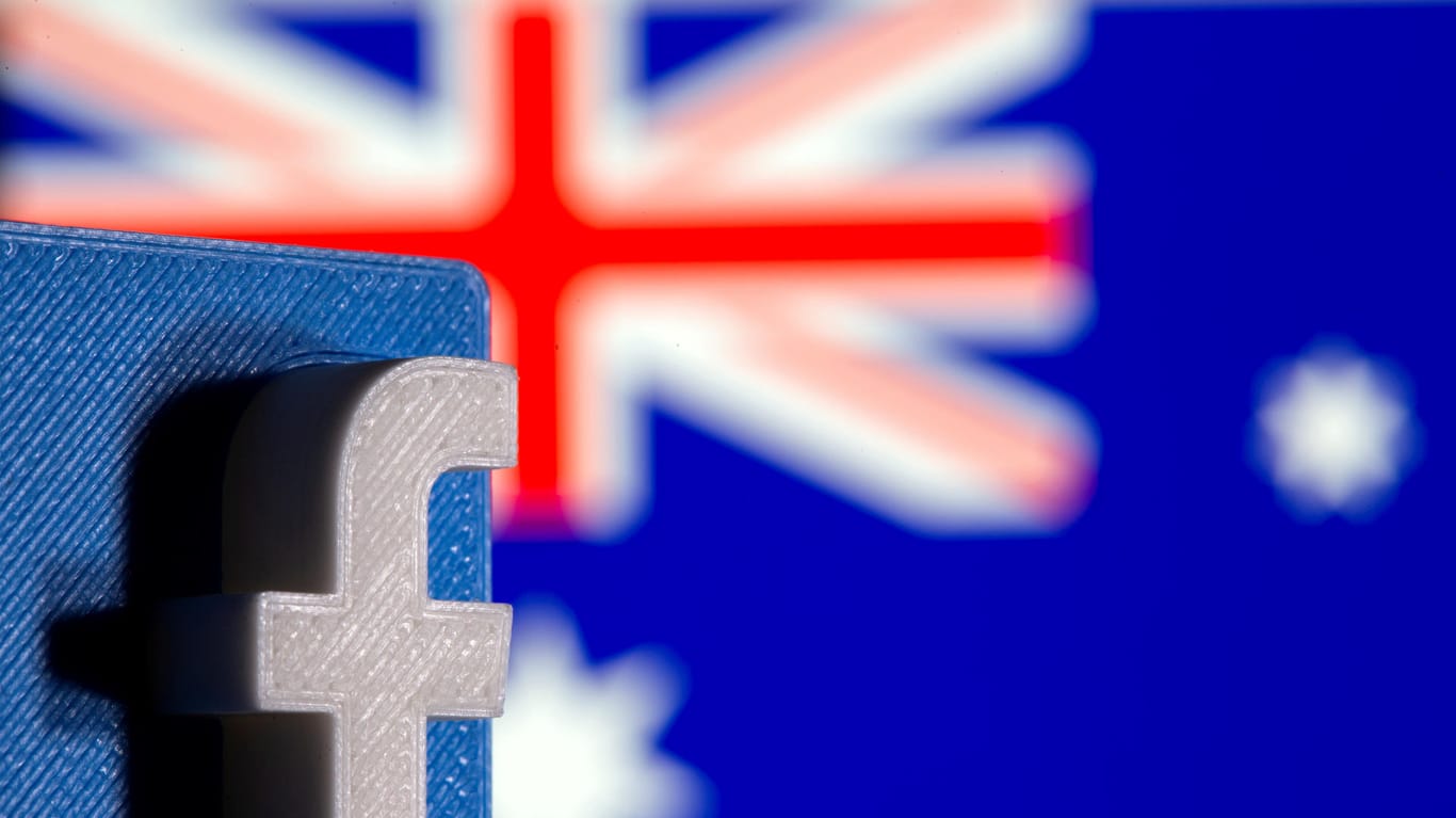 Das Logo von Facebook mit der australischen Flagge im Hintergrund: Der Streit mit Facebook geht in die nächste Runde.