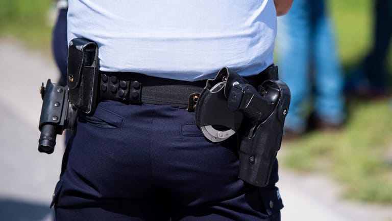 Eine Pistole am Gürtel eines Polizisten (Symbolbild): Als Polizeibeamte bei einer Festnahme in Frankfurt angegriffen wurden, hat einer von ihnen einen Warnschuss abgegeben.