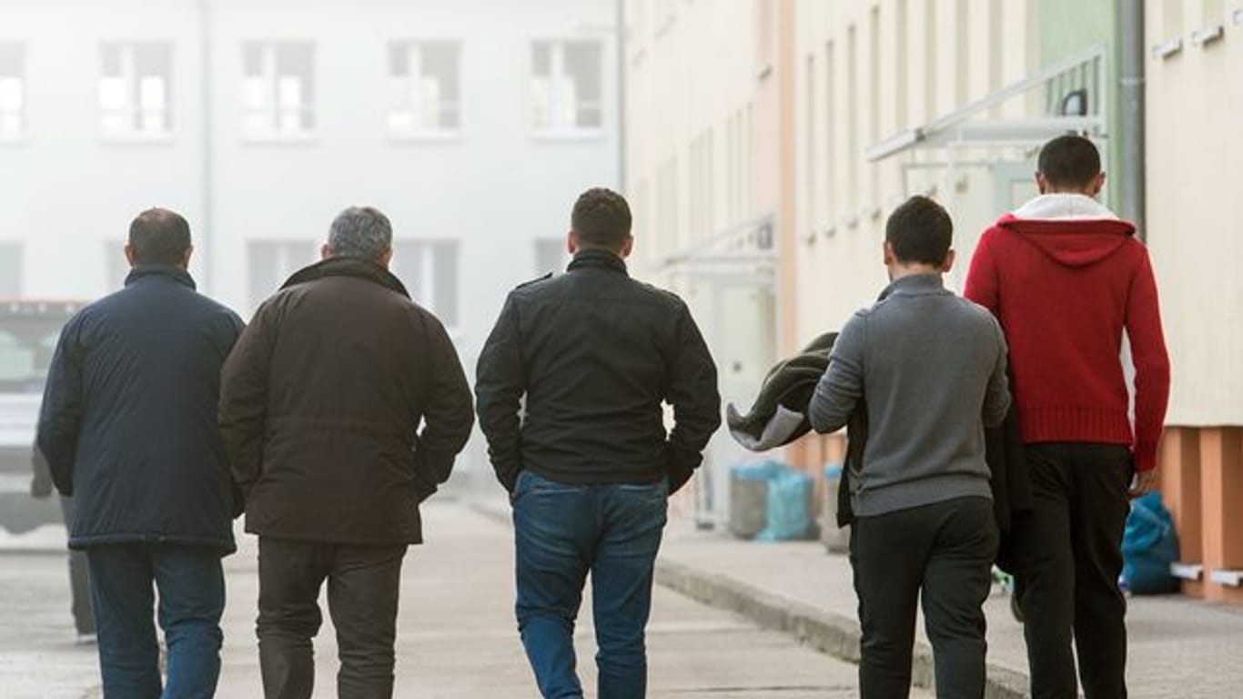 Männliche Asylbewerber gehen über das Gelände der Zentralen Ausländerbehörde (ZABH) in Eisenhüttenstadt.