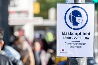 Ein Schild weist am Steindamm in St. Georg auf die dort geltende Maskenpflicht hin (Archivbild): Spätestens ab dem Wochenende soll auch an stark besuchten Orten wie Stadtpark oder Jungfernstieg eine Maskenpflicht herrschen.