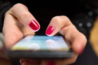 Eine Frau bedient ein Smartphone (Symbolbild): Der Gebrauch von Datenroaming ist vom Sommer 2016 bis zum Sommer 2019 um das 17-fache gestiegen.