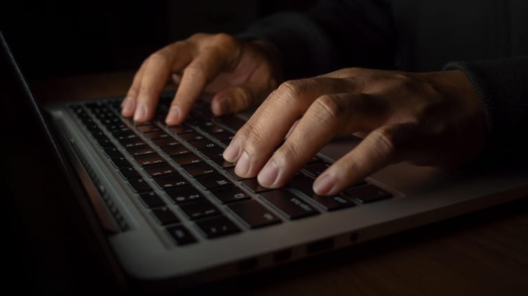 Eine Hand an einem Rechner: Die Europäische Kommission warnt vor Mails, die an T-Online-Nutzer gerichtet sind.