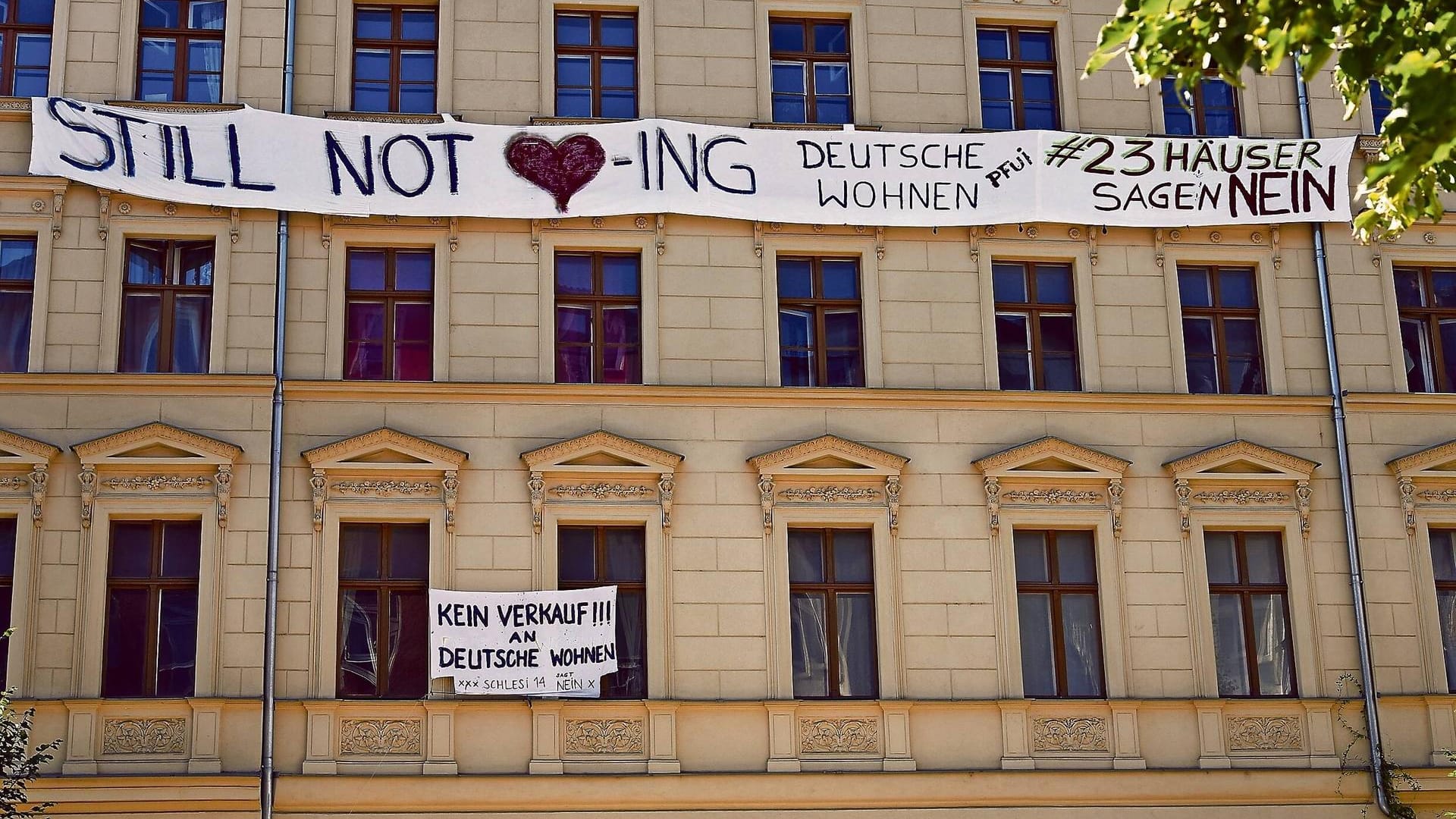 Ein Protestplakat gegen die Deutsche Wohnen an einem Haus (Symbolhbild): Das Unternehmen sollte ein Bißgeld von 14,5 Millionen Euro zahlen.