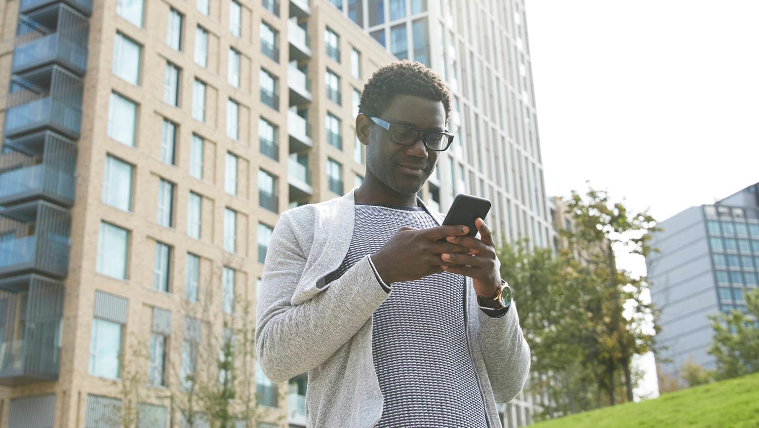 Junger Mann mit Smartphone (Symbolbild): Eine Auswertung zeigt, wie viel man in Deutschlands größten Städten verdient.