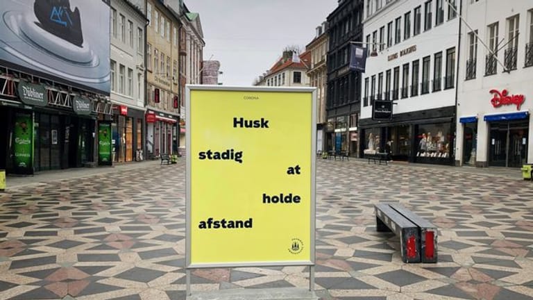 Ein Schild weist in der Fußgängerzone von Kopenhagen auf die Einhaltung der Abstandsregeln hin.