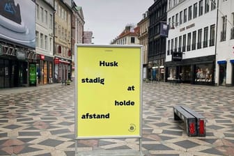 Ein Schild weist in der Fußgängerzone von Kopenhagen auf die Einhaltung der Abstandsregeln hin.