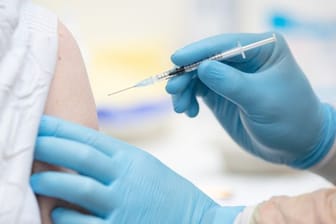 Eine Person wird im Impfzentrum in den Emslandhallen in Lingen mit dem Wirkstoff von Biontech/Pfizer gegen Covid-19 geimpft.