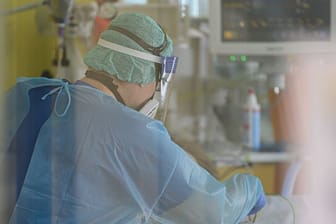 Ein Intensivpfleger ist auf der Covid-19 Intensivstation mit der Versorgung von Corona-Patienten beschäftigt.
