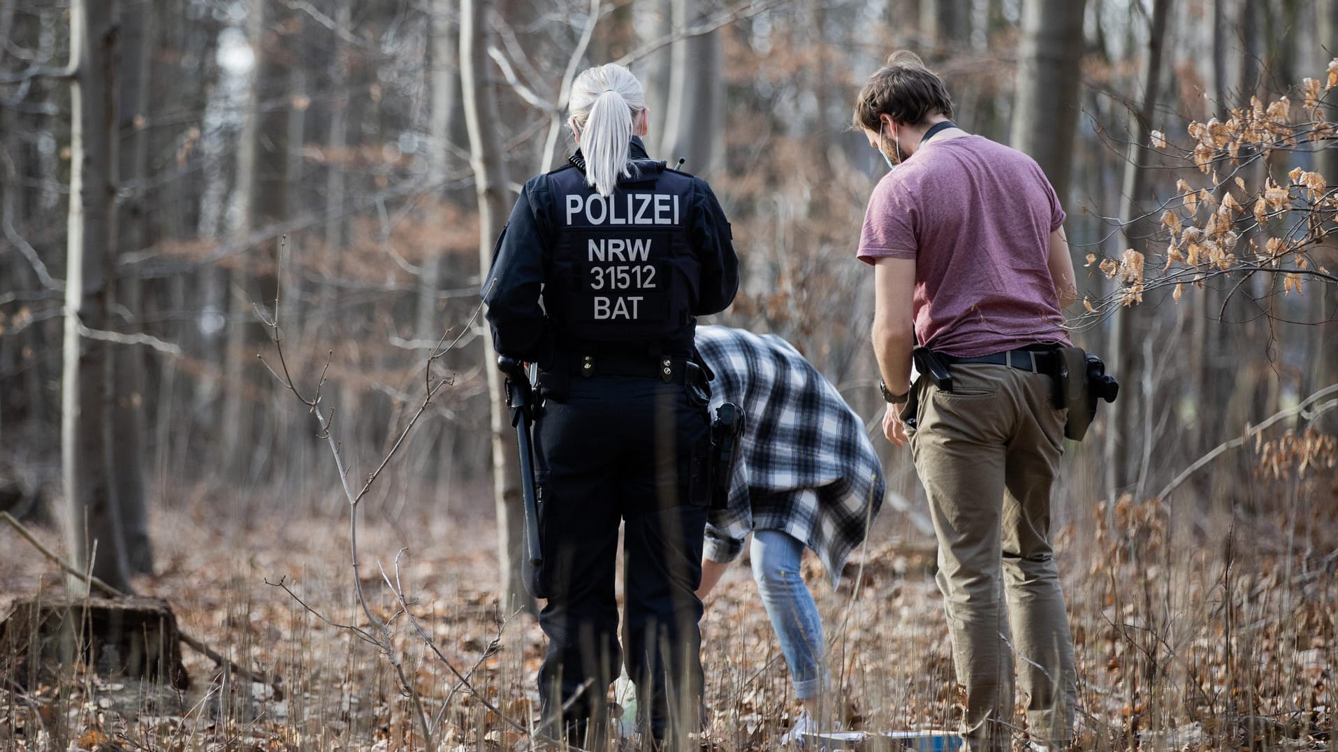 Polizeibeamte und Kriminalbeamte durchsuchen ein Waldstück im Stadtwald nach Spuren: Nach der Vergewaltigung einer Joggerin am Kölner Decksteiner Weiher befürchtet die Polizei eine Wiederholungstat.