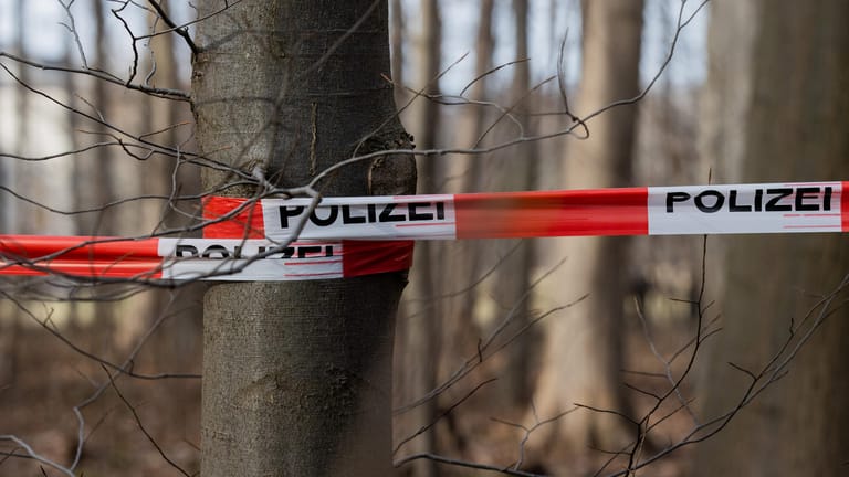 Eine Polizeiabsperrung ist bei einer Durchsuchung eines Waldstücks in Köln zu sehen: Eine Joggerin war beim Decksteiner Weiher vergewaltigt worden.
