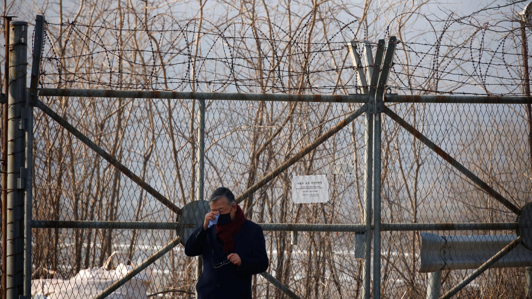 Ein Mann wischt sich am innerkoreanischen Grenzzaun Tränen aus dem Gesicht: Tausende ehemalige Kriegsgefangene aus dem Süden und deren Nachfahren sollen zur Arbeit in Bergwerken gezwungen worden sein.