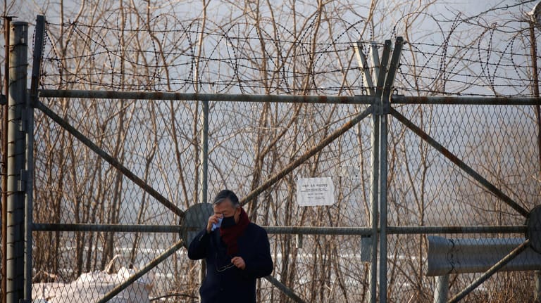 Ein Mann wischt sich am innerkoreanischen Grenzzaun Tränen aus dem Gesicht: Tausende ehemalige Kriegsgefangene aus dem Süden und deren Nachfahren sollen zur Arbeit in Bergwerken gezwungen worden sein.