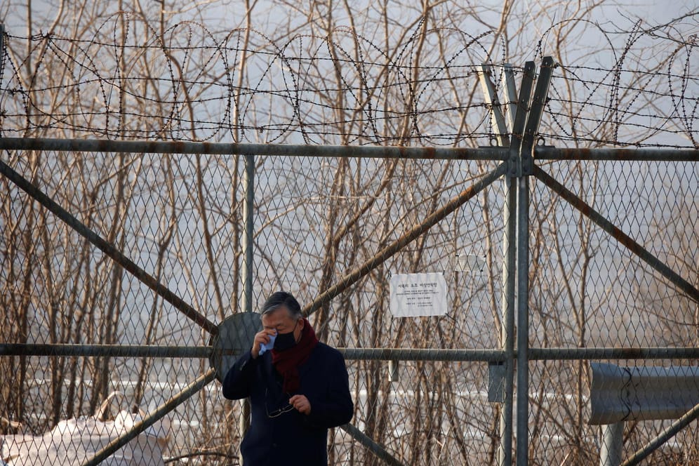 Ein Mann wischt sich am innerkoreanischen Grenzzaun Tränen aus dem Gesicht: Tausende ehemalige Kriegsgefangene aus dem Süden und deren Nachfahren sollen zur Arbeit in Bergwerken gezwungen worden sein.