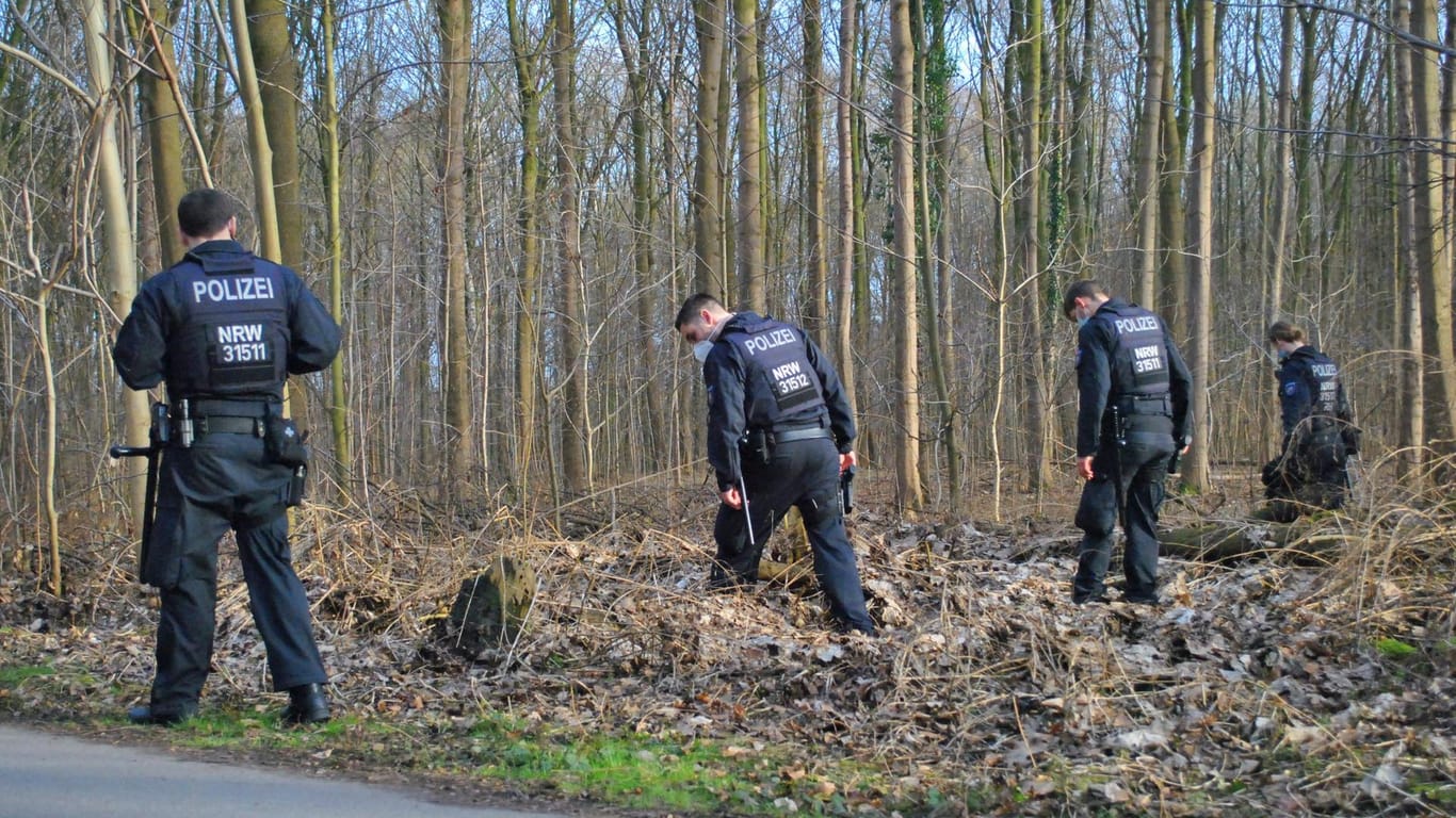 Mehrere Polizisten durchkämmen das Unterholz: Die Suchaktion rund um den Tatort war nach neuesten Erkenntnissen wohl umsonst.