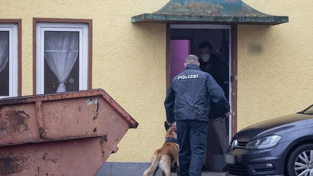 Ein Polizist geht mit einem Drogenspürhund in ein Haus im thüringischen Ballstädt. Ein Polizist geht mit einem Drogenspürhund in ein Haus im thüringischen Ballstädt.