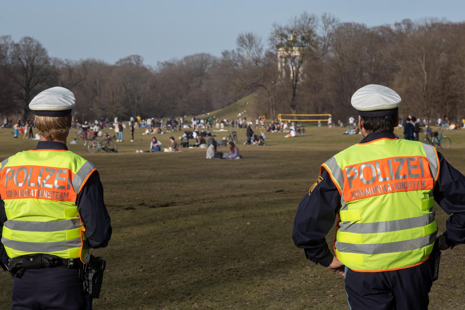 Polizisten kontrollieren im Englischen Garten in München, ob die Menschen den vorgeschriebenen Corona-Abstand einhalten.