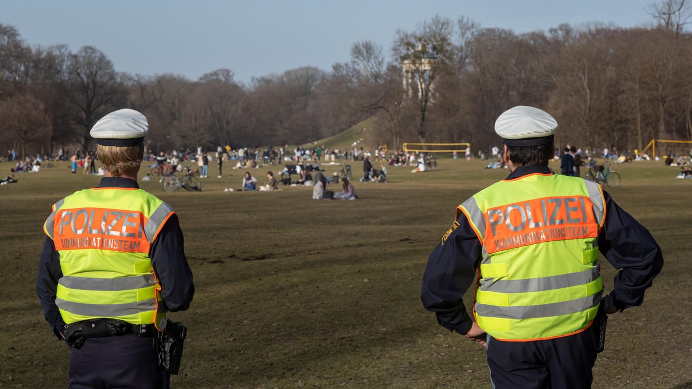 Polizisten kontrollieren im Englischen Garten in München, ob die Menschen den vorgeschriebenen Corona-Abstand einhalten.