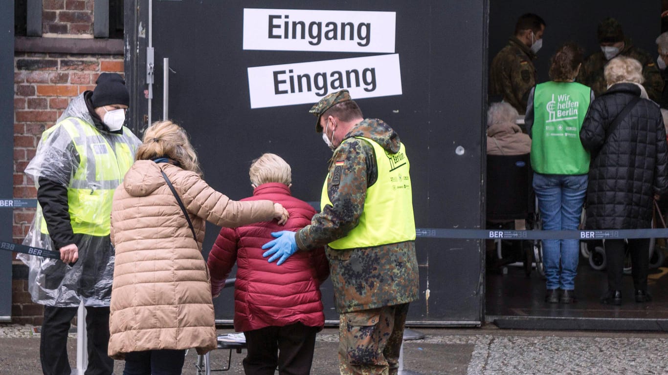Ankunft am Impfzentrum in der Arena in Treptow: Ein Bundeswehr Soldat hilft einer älteren Frau.