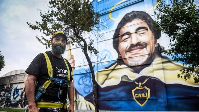 Der Künstler Alfredo Segatori steht vor seinem Wandgemälde im Viertel La Boca zu Ehren des "Goldjungen" Maradona.