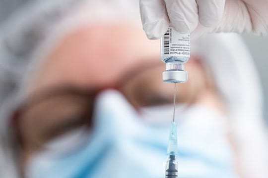 Eine Ampulle mit einem Vakzin: Trotz der Impfungen steigen die Corona-Neuinfektionen weiter an.