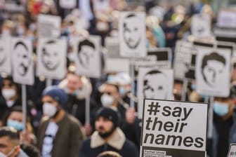 Ein Plakat mit der Aufschrift "#say their names" wird auf einer Kundgebung zum Gedenken an den rassistischen Anschlag in Hanau hochgehalten.