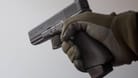 Eine Person hält eine Pistole in der Hand (Symbolbild): In Frankfurt wurden zwei Wettbüros überfallen.