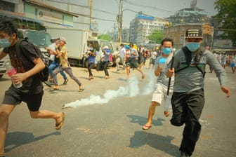 Demonstranten flüchten in Rangun vor Sicherheitskräften: Polizisten haben mehrere Menschen getötet.
