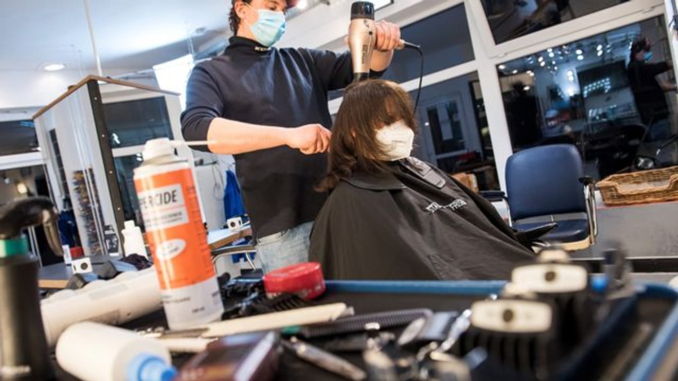 Henry Riehl föhnt einer Kundin die Haare: Der Friseur öffnete seinen Laden bereits um Mitternacht.
