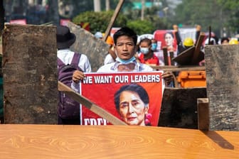 "Wir wollen unsere Anführer": Ein Protestteilnehmer hält in Rangun ein Plakat mit dem Bild von Aung San Suu Kyi.