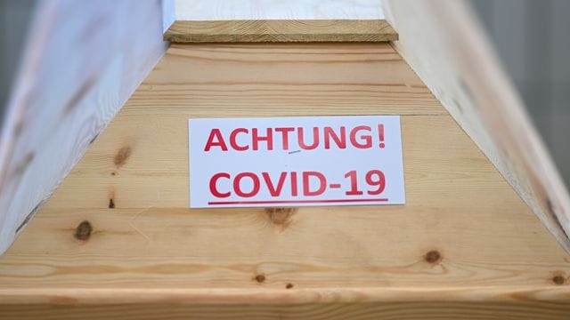 Ein Sarg mit der Aufschrift "Achtung! Covid-19" steht in einem Krematorium in Baden-Württemberg.