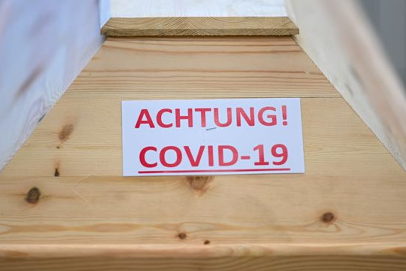 Ein Sarg mit der Aufschrift "Achtung! Covid-19" steht in einem Krematorium in Baden-Württemberg.