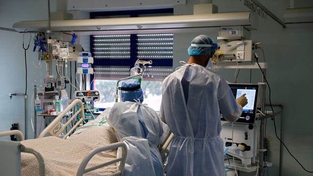 Eine Krankenschwester und ein Arzt kümmern sich um einen Patienten auf der Corona-Intensivstation in einem Lissaboner Krankenhaus. Eine Krankenschwester und ein Arzt kümmern sich um einen Patienten auf der Corona-Intensivstation in einem Lissaboner Krankenhaus.