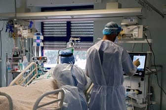 Eine Krankenschwester und ein Arzt kümmern sich um einen Patienten auf der Corona-Intensivstation in einem Lissaboner Krankenhaus.