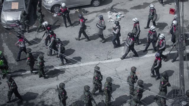 Soldaten und Bereitschaftspolizisten bei einem Protest in Rangun. Soldaten und Bereitschaftspolizisten bei einem Protest in Rangun.