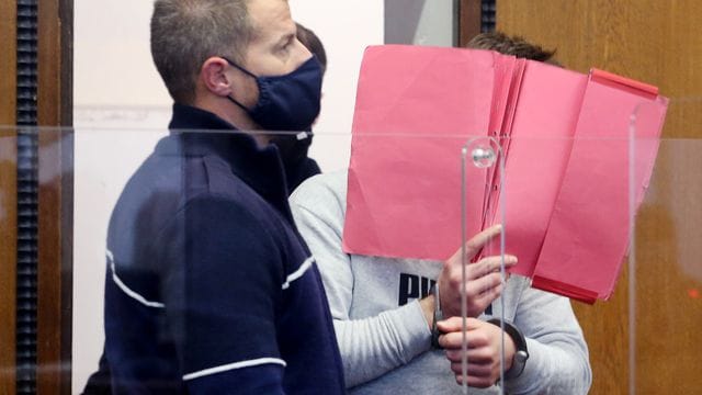 Der wegen Totschlags angeklagte Mann wird von einem Justizbeamten in den Gerichtssaal geführt. Der wegen Totschlags angeklagte Mann wird von einem Justizbeamten in den Gerichtssaal geführt.