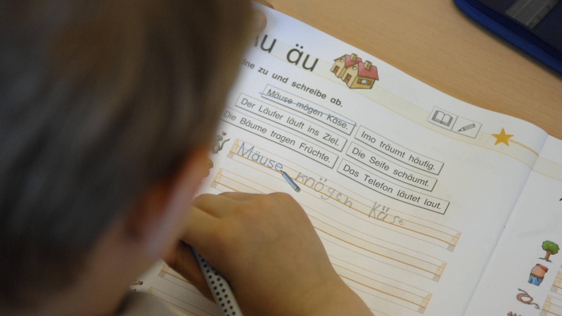 Ein Kind sitzt über einem Schulheft (Symbolbild): Vor Gericht haben zwei Schüler Beschwerde gegen den Präsenzunterricht eingereicht. Ein Kind sitzt über einem Schulheft (Symbolbild): Vor Gericht haben zwei Schüler Beschwerde gegen den Präsenzunterricht eingereicht.