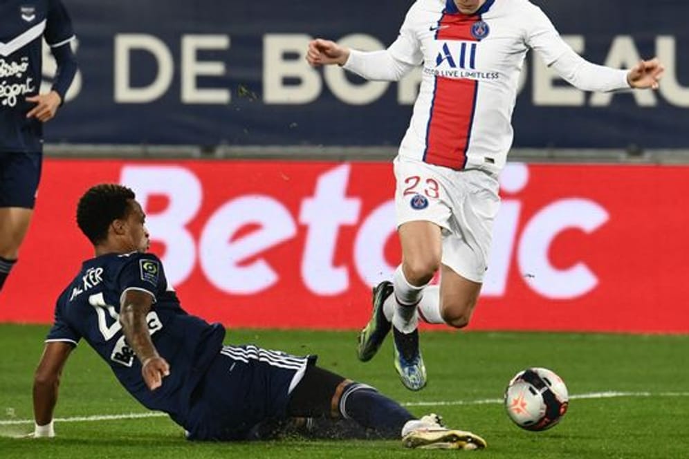 Bordeaux-Verteidiger Edson Mexer (M) kämpft mit Julian Draxler (r) von Paris Saint-Germain um den Ball.