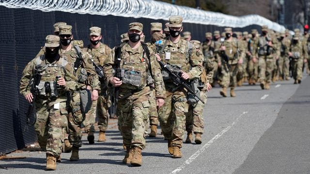 Soldaten der Nationalgarde patrouillieren entlang eines Sicherheitszauns vor dem US-Kapitol in Washington. Soldaten der Nationalgarde patrouillieren entlang eines Sicherheitszauns vor dem US-Kapitol in Washington.