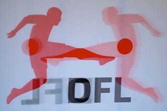 Das Logo der DFL (Deutsche Fußball Liga) spiegelt vor einer Pressekonferenz in einer Plexiglasscheibe.