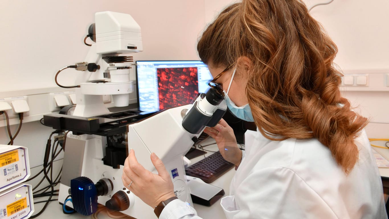Wissenschaftlerin untersucht Probe im Labor: Das Robert Koch-Institut meldete mehr als 10.000 Neuinfektionen.
