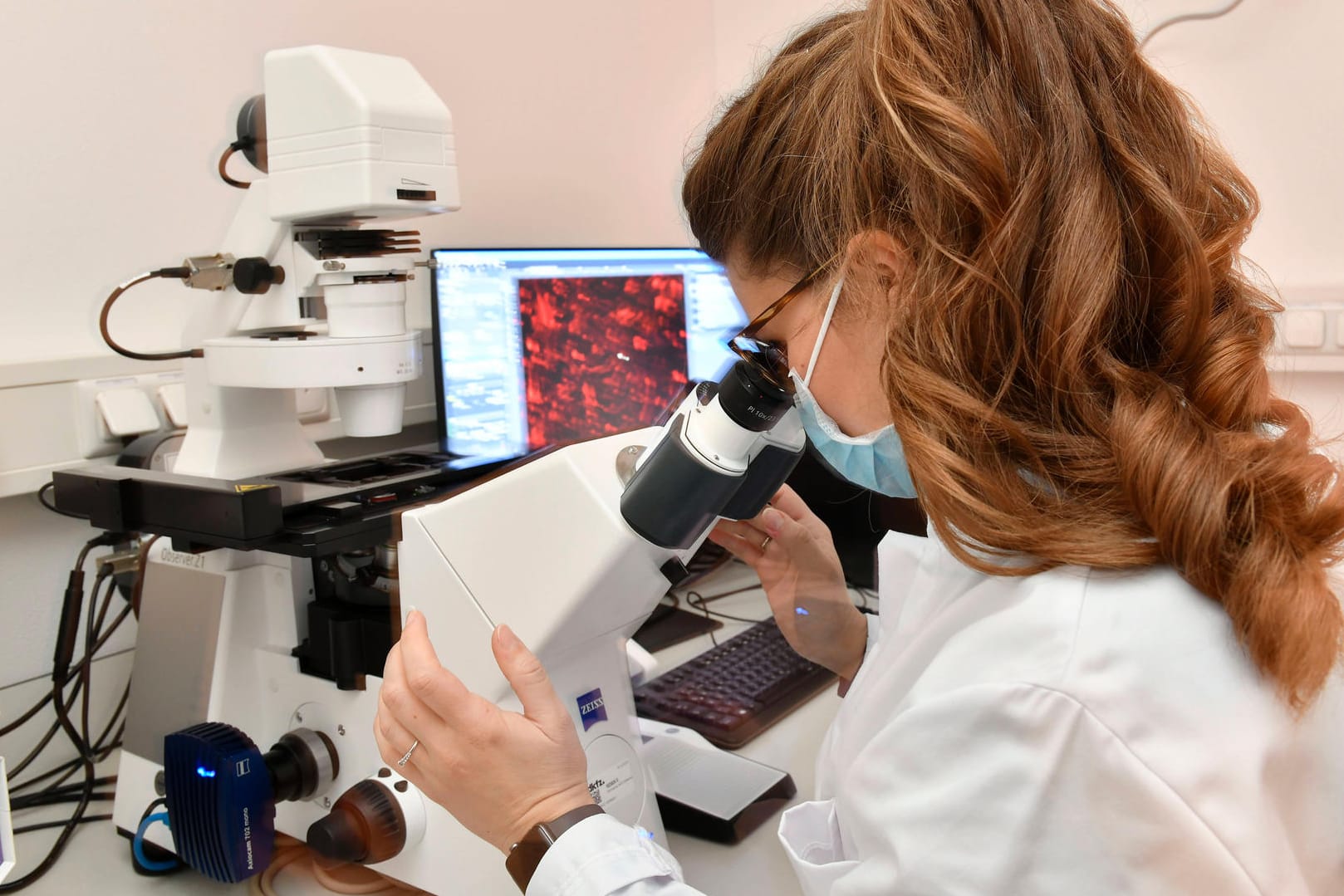 Wissenschaftlerin untersucht Probe im Labor: Das Robert Koch-Institut meldete mehr als 10.000 Neuinfektionen.