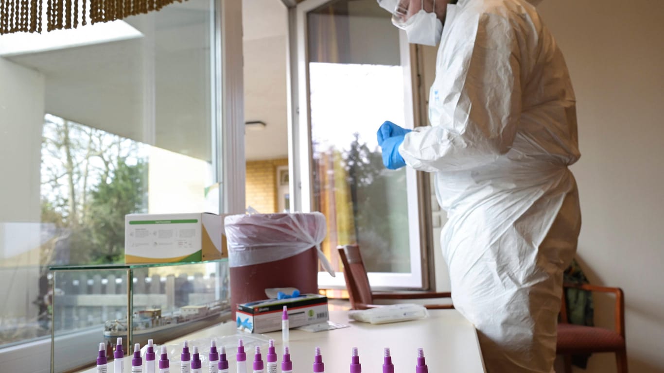 Ein Mann wertet Schnelltests aus (Symbolbild): In einer Fleischfabrik im Kreis Karlsruhe hat es einen Corona-Ausbruch gegeben.