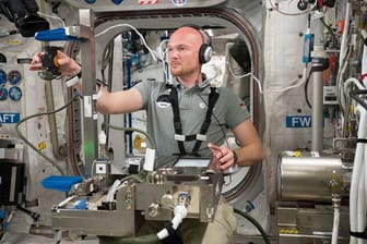Der deutsche Astronaut Alexander Gerst führt ein Experiment auf der Internationalen Raumstation ISS durch.