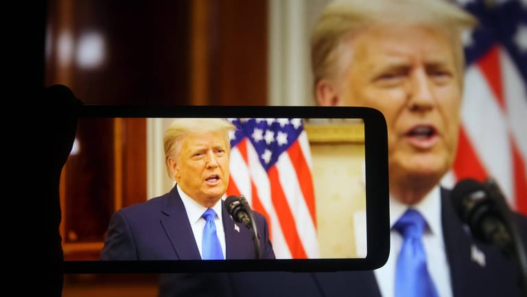 Ex-US-Präsident Donald Trump wird mit einem Smartphone gefilmt: Trumps YouTube-Konto bleibt gesperrt.