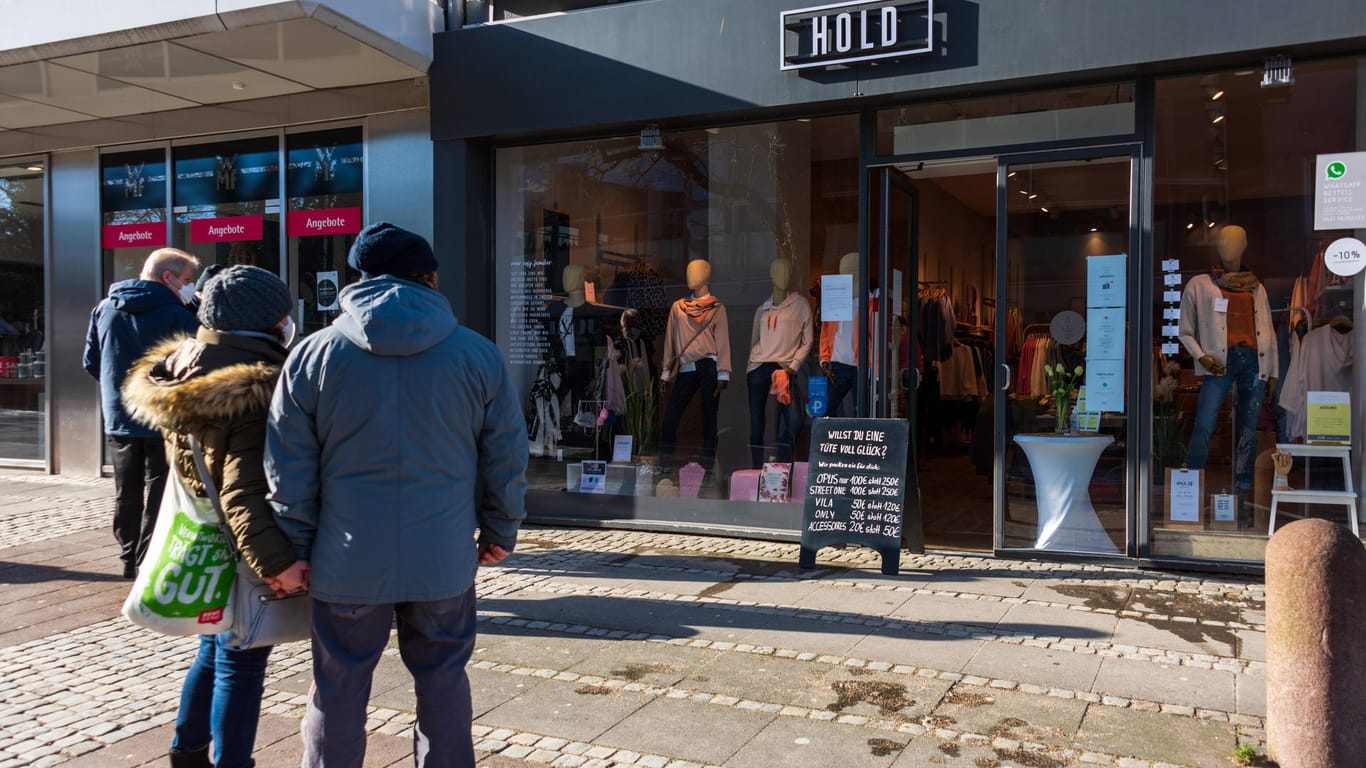 Kieler stehen vor einem für die Abholung geöffneten Geschäfts in der Innenstadt (Archivbild): Die Stadt setzt bei der Öffnung des Einzelhandels und der Gastronomie auch auf die Luca-App.