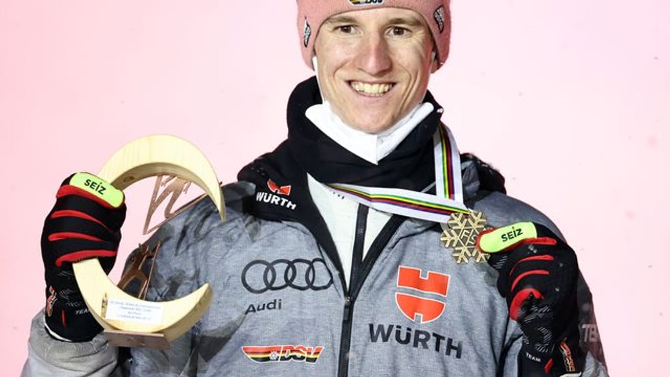 Karl Geiger posiert bei der Siegerehrung mit der Bronzemedaille.