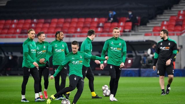 Die Gladbacher Spieler wärmen sich in der Puskas Arena auf - zum Rückspiel soll es nach Manchester gehen.