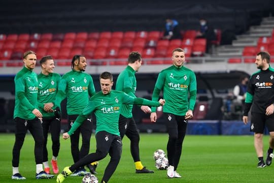 Die Gladbacher Spieler wärmen sich in der Puskas Arena auf - zum Rückspiel soll es nach Manchester gehen.