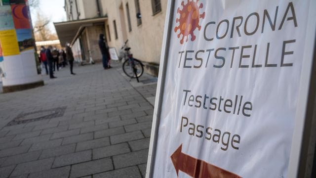 Ein Schild weist den Weg zu einer "Corona-Teststelle".