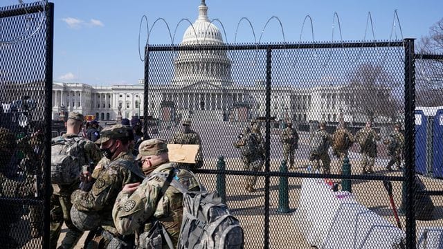 Soldaten der Nationalgarde gehen durch das Tor eines Sicherheitszauns vor dem Kapitol. Soldaten der Nationalgarde gehen durch das Tor eines Sicherheitszauns vor dem Kapitol.